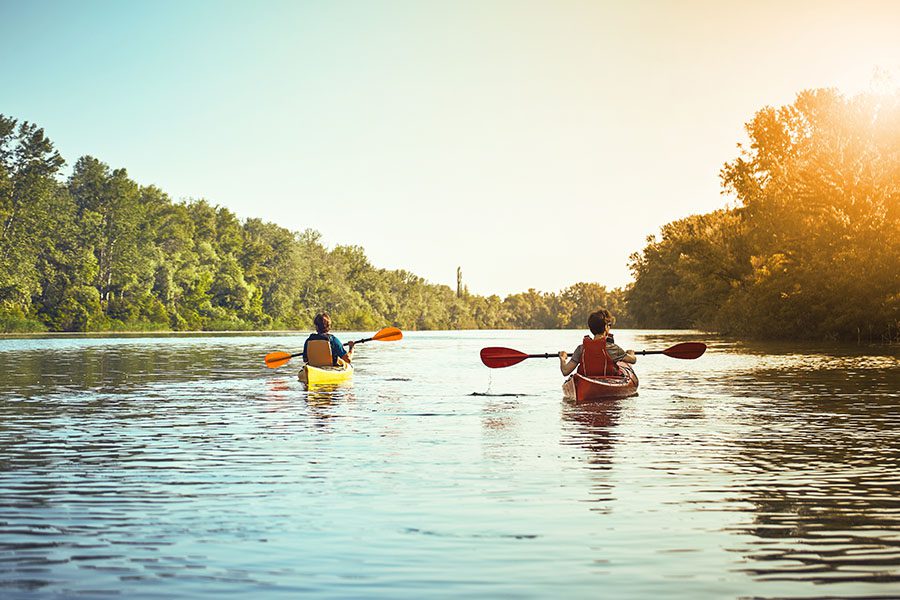 About Our Agency - Two Men Kayaking on a River